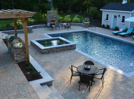 pool and spa with outdoor kitchen and tables
